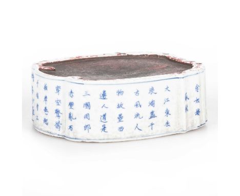 A CHINESE INSCRIBED BLUE AND WHITE PORCELAIN INKSTONE of shaped, undulating outline with calligraphic inscription, probably K