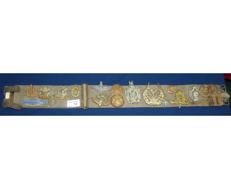 WWII period webbing belt mounted with various military cap badges, mostly British including two American and one Italian incl