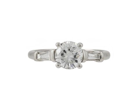 A SINGLE STONE DIAMOND RING  The brilliant cut diamond weighing 1.02 carats, between tapered baguette cut diamond shoulders, 