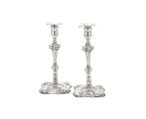 A PAIR OF GEORGE III CAST SILVER CANDLESTICKS EBENEZER COKER, LONDON 1760 With shaped square sconces with foliage to the corn