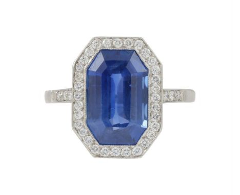 AN ART DECO SAPPHIRE AND DIAMOND CLUSTER RING  CIRCA 1925  The octagonal cut sapphire estimated to weigh 5.19 carats, within 