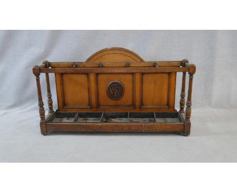 A late 19th century oak Aesthetic style hallstand with arched back and carved monogram and a five section stick and umbrella 