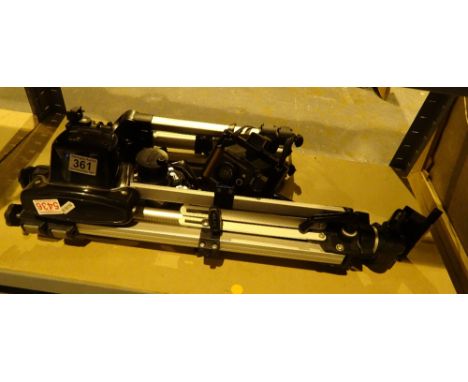 Two camera tripods and a Polaroid land camera
