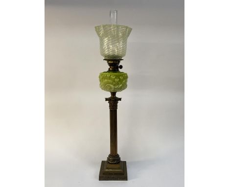A Victorian brass oil lamp, having a frilled glass shade resting upon a moulded opaque glass reservoir above a brass corinthi
