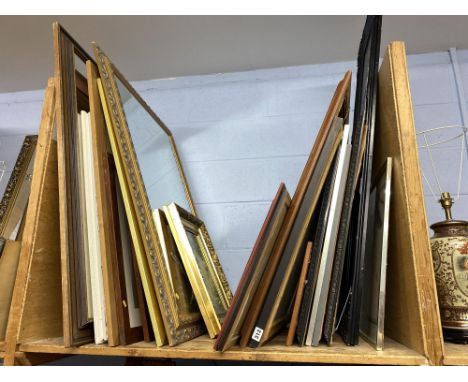 A shelf of 20th Century oils on canvas, coloured and monochrome prints and mirrors
