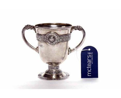 IRISH SILVER TWIN HANDLED CUP
maker George Edward & Sons, Dublin 1920, cast with Celtic scroll work borders and roundels to b