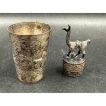 Two silver curios marked 925, a camel on plinth and a beaker