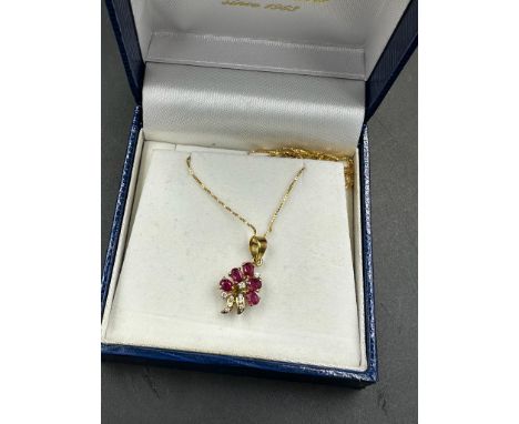 An 18ct, marked 750, chain with diamond and ruby floral themed pendant, approximate total weight 2.6g, 