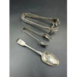 A small selection of silver items two pairs of sugar tongs and a teaspoon