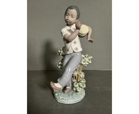 A Lladro figure of a young boy playing a drum