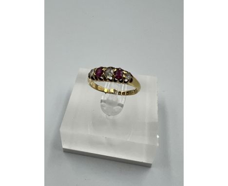 An 18ct yellow gold diamond and ruby ring, approximate size M