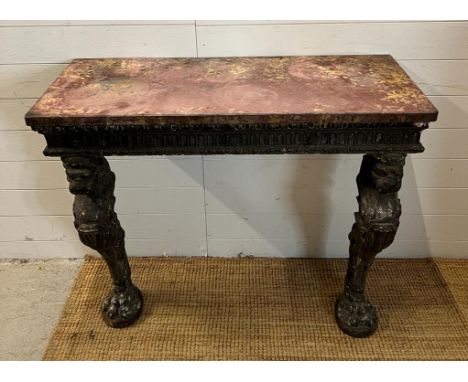 A carved console table with carved lion head supports terminating with lion paws on marble top (H87cm W106cm D44cm)