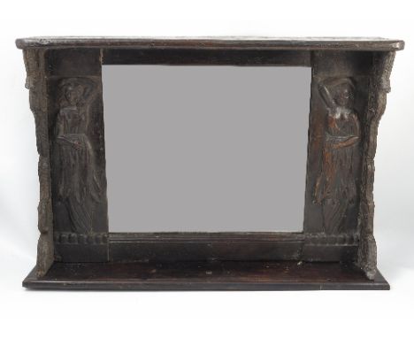 An Antique oak framed wall mirror, the rectangular mirror plate flanked by two carved figures and carved scroll edges, with s