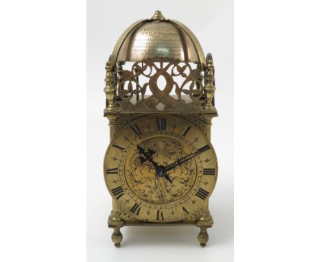 A brass lantern clock, in the Antique style, the bell engraved with presentation inscription, with gilt chapter ring, Roman n