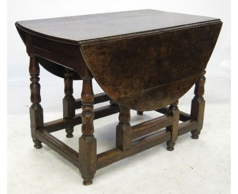 An 18th century oak oval gate leg dining table, raised on turned legs united by stretchers, 42ins x 53ins
