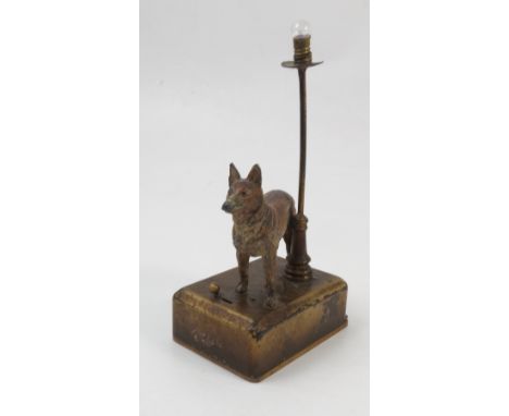 A painted lead model, of a standing dog, mounted on a rectangular metal base with light fitting, the base with wooden slide r