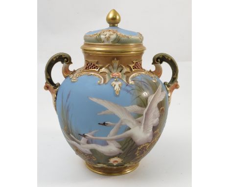 A Royal Worcester covered vase, with scroll handles having a powder blue ground, decorated with swans, by C H C Baldwyn, shap