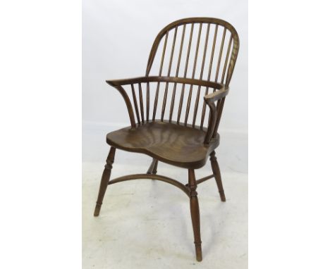 A set of four Windsor armchairs, with stick backs, raised on turned legs, united by crinoline stretchers
