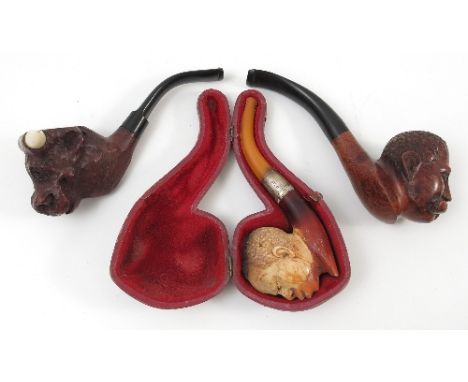 A cased Meerschaum style pipe, carved with a mans head, having a hallmarked silver collar, together with another pipe carved 