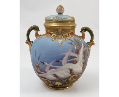 A Royal Worcester covered vase, with scroll handles, having a powder blue ground decorated with swans by C H C Baldwyn, shape