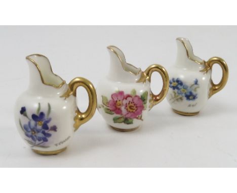 Three miniature Royal Worcester flat back jugs, hand painted with flowers, signed A Davis, J Fuller and A...F, all dated 1955
