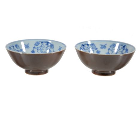  A pair of Chinese bowls,   the interiors painted with blue and white with dancing figures, the exteriors   cafe-au-lait  ,  