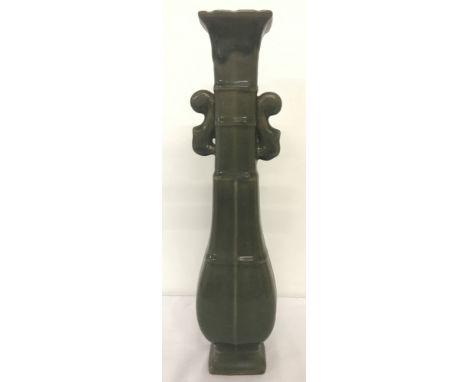 A tall green glazed ceramic Chinese vase with decorative handles. Signed to underside. Approx. 39.5cm tall.