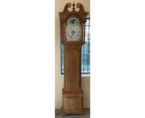 A modern pine cased grandfather clock with quartz movement. Clock face has glass fronted door and is surrounded with column d