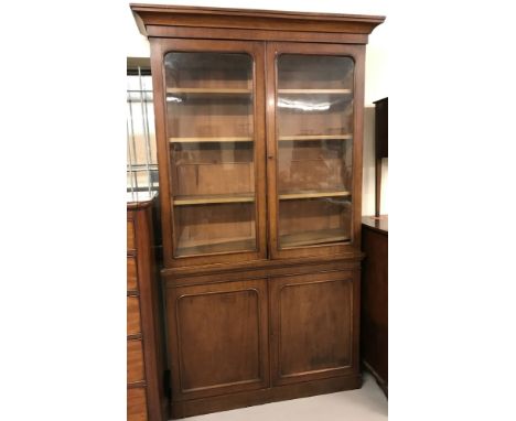 An antique, oak glass fronted 2 sectional bookcase with double cupboard to base. Top section has 4 interior moveable shelves 