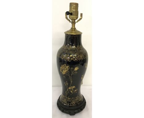 A Japanese black ceramic lamp base with gilt decoration. Mounted on a circular wooden base and with brass light fitting. Tota