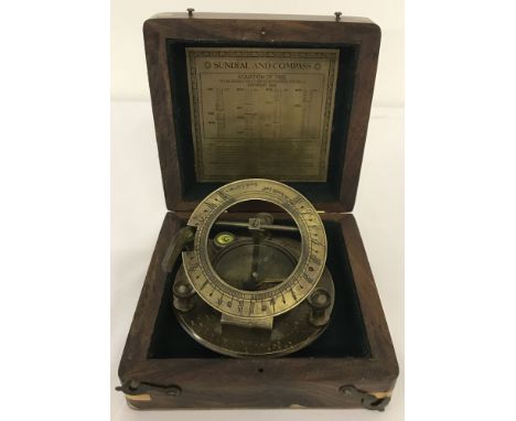 A brass sundial and compass in wooden box.  Box approx. 13.5cm x 14cm x 5.5cm when closed.