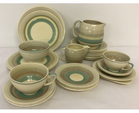 A Susie Cooper part tea service in "Wedding Ring" pattern. In two colourways. Comprising 31 pieces to include plates. 1 large