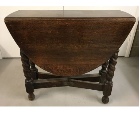 A small dark oak, barley twist, drop leaf table with gate leg opening.  Approx. 72cm tall x 76cm wide in closed position.