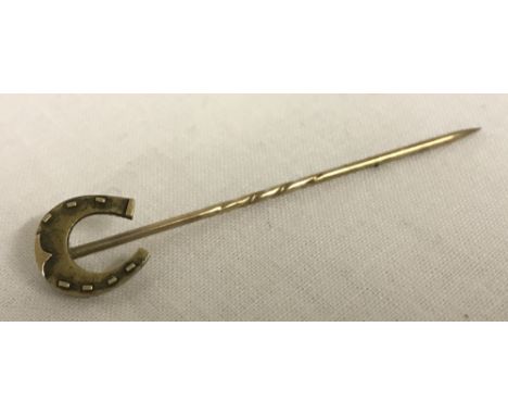 A decorative horseshoe stick pin. Tests as 9ct.  