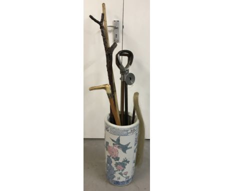 A Chinese ceramic stick/umbrella stand together with a selection of sticks.  