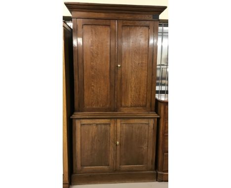 A vintage oak 4 door, 2 sectional cupboard on cupboard. Top section has 3 interior shelves, base has 2 interior drawers and a
