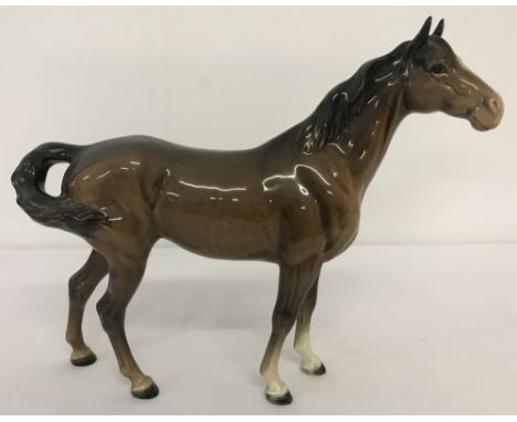 A Beswick ceramic horse, swish tail, figurine #1182, first version with higher tail. In brown, gloss finish, discontinued in 
