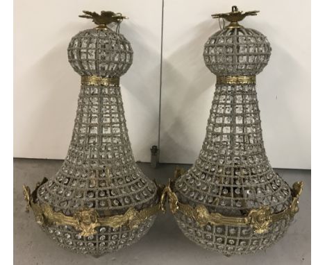 A pair of heavily beaded hanging chandelier style lampshades. With brass detail depicting classical faces. Approx. 77cm tall 