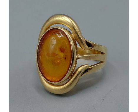 An 18ct gold ring set with cabochon Amber within a pierced setting, 8gms, ring size O