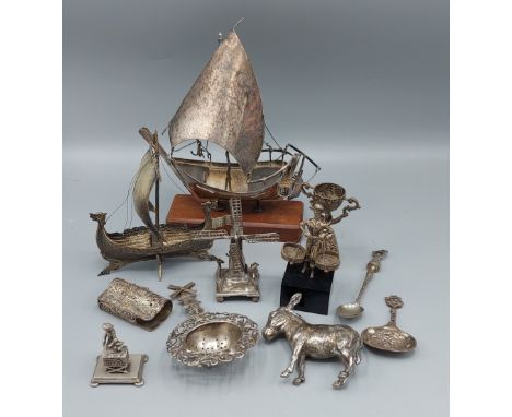 A white metal model of a boat together with a collection of continental white metal items to include figures and spoons 