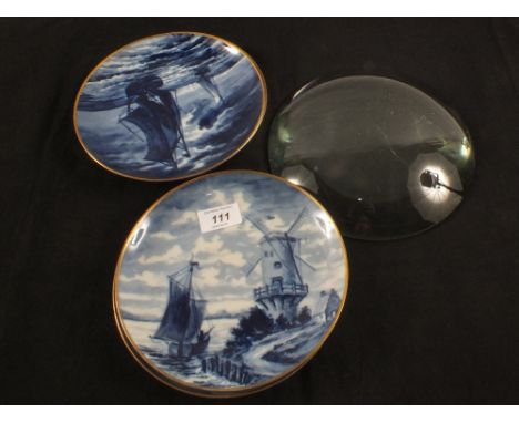 Four German porcelain Delft style blue and white plates plus a glass lens