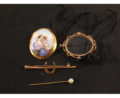 A 9ct gold brooch in the form of a horn and horse shoe together with a 9ct gold framed magnifier, a yellow metal mounted porc