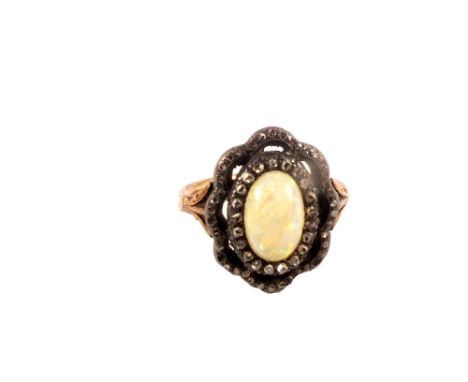 A yellow and white metal ring set with opal stone to centre with fancy border set with diamonds (some are missing), size I