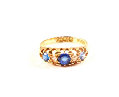 An 18ct gold ring set with three blue stones and two diamonds (one chipped), size K