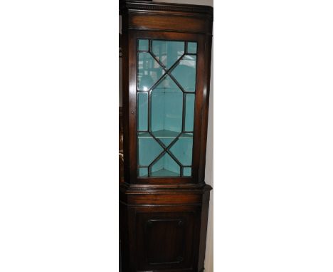 A George III style mahogany standing corner cupboard, the upper section with astragal panel door, the base with a panel door 