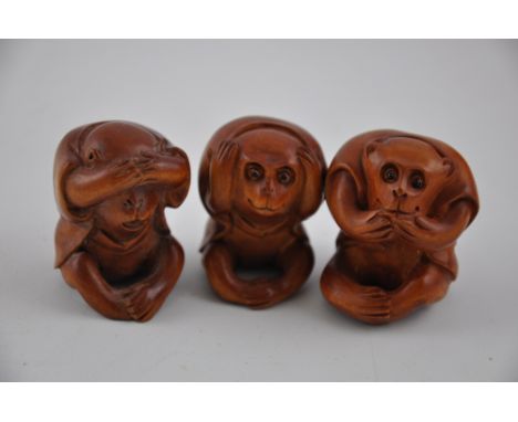Three carved hardwood netsuke in the form of the Three Wise Monkeys, H. 4cm. 