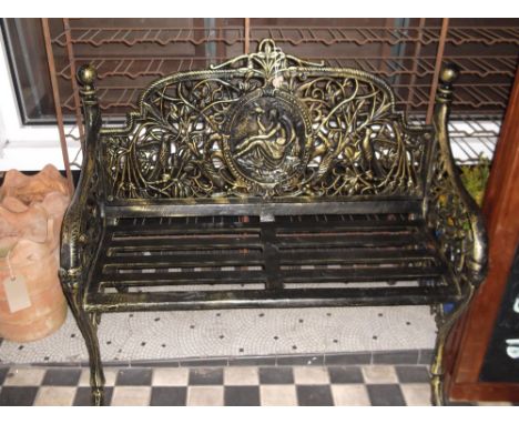 A cast iron garden bench, finished in black and gold, the back  incorporating an oval trophy, W. 106cm.