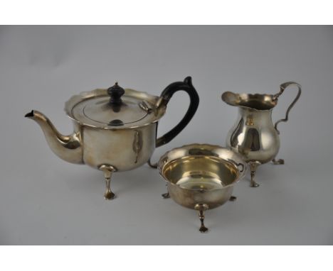 A three piece sliver bachelor tea service, Birmingham 1898, with ebonised fittings and ogee rim and pad feet, 12ozt.