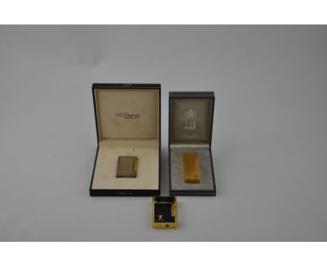 A Dupont gas lighter, the white metal rectangular graduated ribbed body with a gilt roller, together with original box, also 