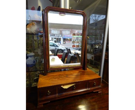 A George III design cable inlaid mahogany toilet mirror, the rectangular plate with a gilt slip over three drawers on bracket